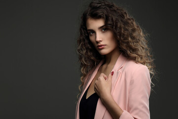 Fototapeta premium Portrait of a beautiful girl with highlighted hair on a dark background