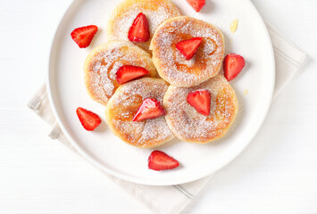 Cottage cheese pancakes with strawberry slices and honey