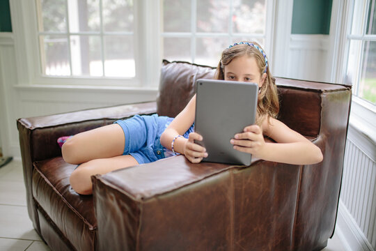 Beautiful young girl in a tie dye shirt and socks using a tablet