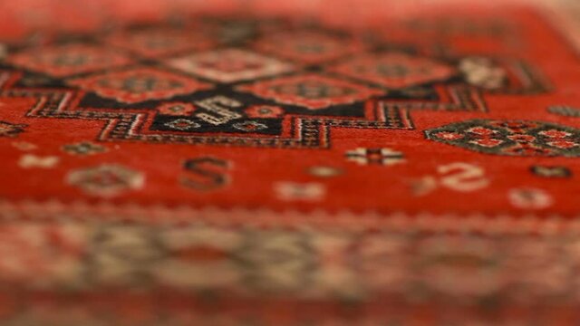 red black pattern of the Persian Carpet, soft woolen texture close-up, motion, abstract background