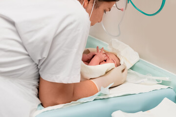 Nurse caring for newborn baby after childbirth