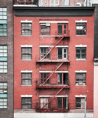 Old brick tenement house with fire escape, color toned picture, New York City, USA.