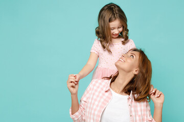 Happy woman in pink clothes have fun with cute child baby girl 5-6 years old Mommy little kid daughter stand behind hug isolated on pastel blue azure background studio Mothers Day love family concept