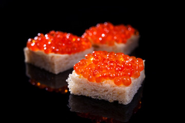 salmon caviar sandwiches on a black background