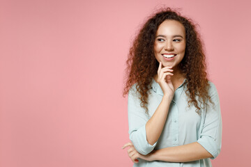 Young black african american happy smiling dreamful pensive curly woman 20s in blue casual shirt...