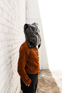person with hiding under trash bag face mask