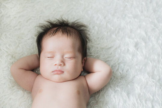 Cute newborn baby sleeps in white