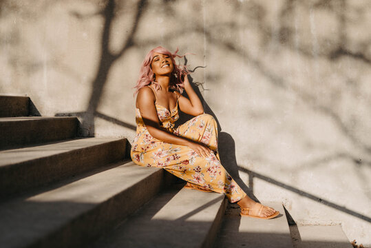 A young african amrican woman wearing a pink wig
