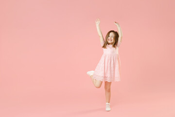 Full length of little kid girl 5-6 years old wears rosy dress have fun dancing fooling around...