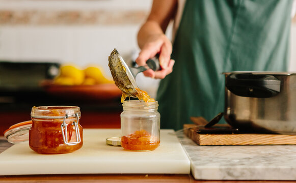 pouring finished marmalade into a jar