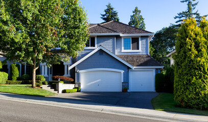 Curb view of a modern home with wooden shingle roof during summer morning - 420522951