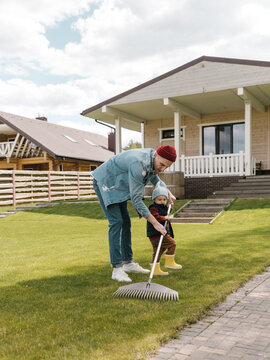 Father and son raking lawn