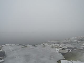 Floating smelting ice snow pieces on the river in spring, norwegian landscape