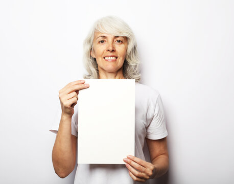 Happy Elderly Lady Holding Blank Sheet In Hand, Smiling