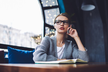 Focused woman speaking on smartphone in cafe