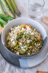 healthy barley soup with spring vegetables, asparagus, wild garlic and carrots