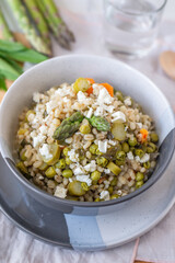 healthy barley soup with spring vegetables, asparagus, wild garlic and carrots