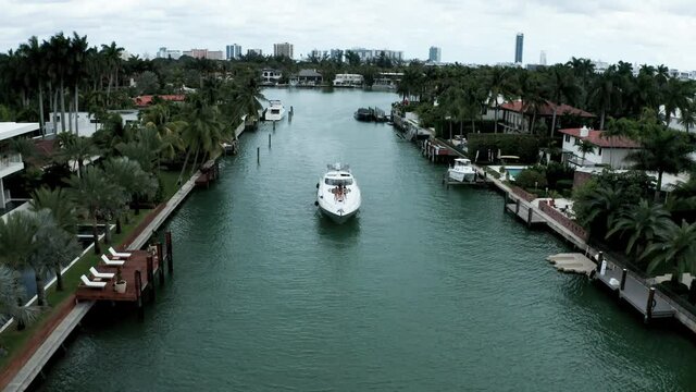 A luxury yacht slowly makes its way through the upscale canals near Miami Florida, aerial