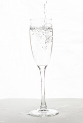 Filling up the champagne glass water  isolated on a white background