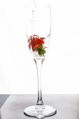 Filling up the champagne glass with strawberry isolated on a white background copy space