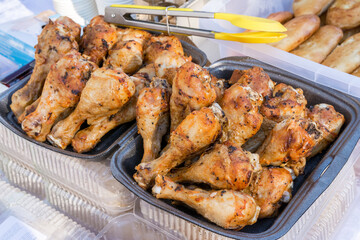 Street food sales. Delicious fried chicken legs are sold.