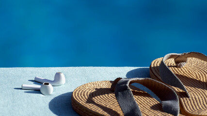 White Wireless Headphones - Bluetooth earphones or earbuds and womens beach flip flops lie near...