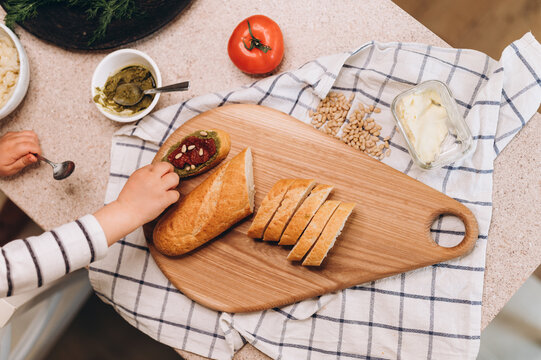 Crop child cooking sandwiches in kitchen
