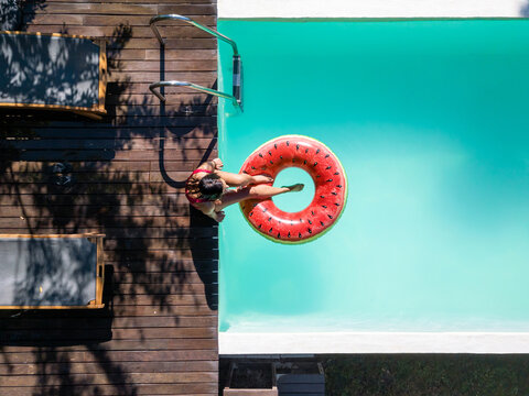 Drone shot of a woman sitting on a pool