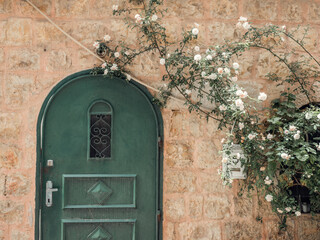 An old green door with flowers in Jerusalem