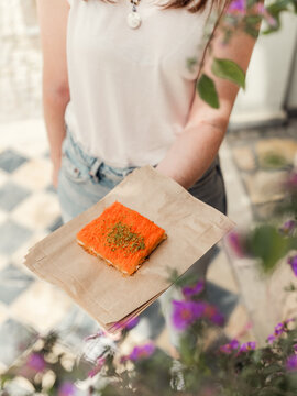 A woman holding some bought Knafeh from a market in Jerusalem
