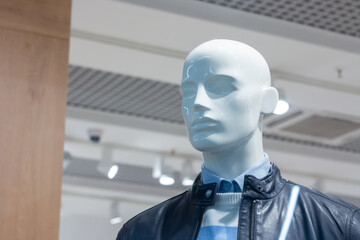 A mannequin behind a shop window in a trade center.