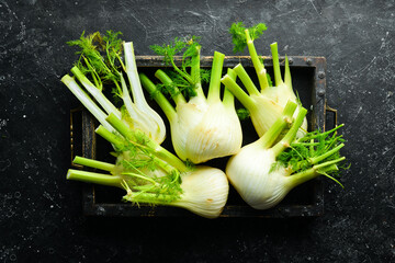 Fresh organic fennel bulbs in a wooden box. Healthy food. Top view. Free space for your text. - obrazy, fototapety, plakaty