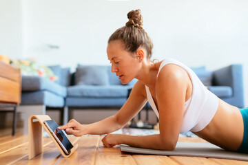 Young woman with tablet preparing for yoga practice