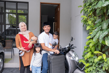 Fototapeta na wymiar asian muslim family riding motorbike scooter together traveling with kid. eid mubarak travel concept