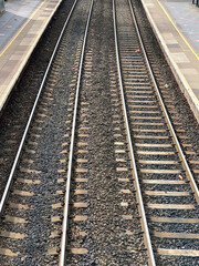 Fototapeta premium Aerial view of railway track and concrete railway sleepers, between platforms at a railway station.. No people.