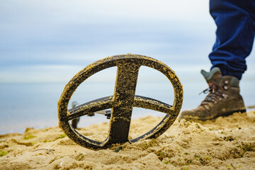 Man with metal detector on sea beach