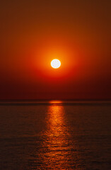 Sea sunset. Red sun on the horizon of the sea. Sunny path in the reflection of the sea.