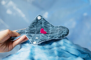 Eco friendly reusable organic gasket made of bio-cotton and females hand are on on the blue...