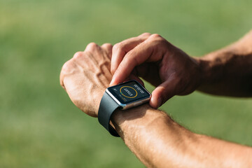 Anonymous man using a digital smartwatch during workout