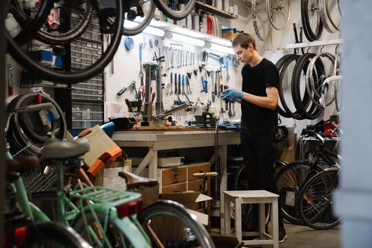 Man Working In Repair Shop Of Bicycles
