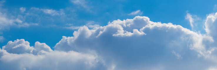White curly clouds on a background of blue sky, panorama