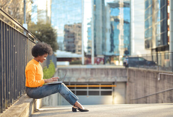 young black woman with computer in the city