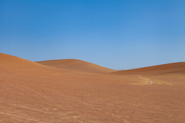 Fototapeta na wymiar Landscape photography of red dunes and sands, in the Paracas desert, on the Lagunillas Route, in the direction of Las Minas Beach in the Paracas National Reserve, Pisco, Ica, Peru.