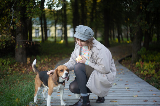 A woman witting and petting a dog