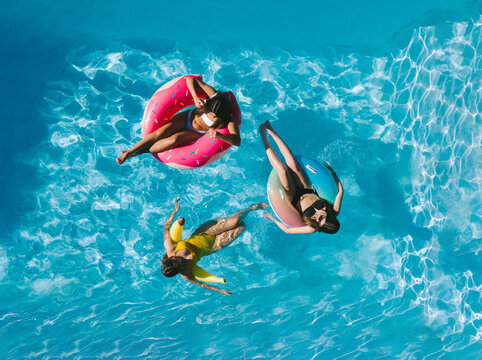 Women in the water in a swimming pool on top of a float