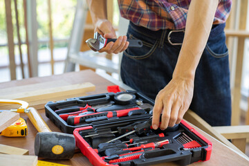 Asian young handyman carpenter work form home for wood work furniture in workshop DIY new normal...