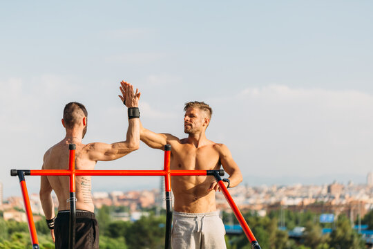 Shirtless sportsmen making high five gesture