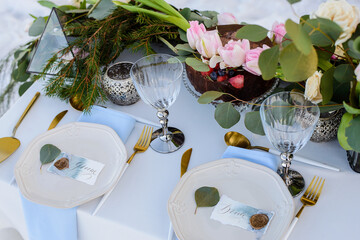 The bride and groom table decorated with greenery, gold cutlery