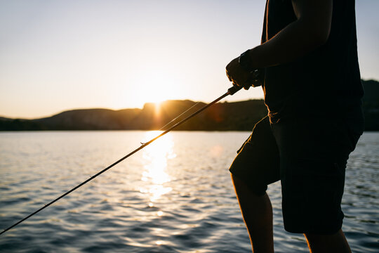 Unrecognizable angler fishing on river