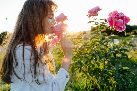 Young woman smelling flowers in park